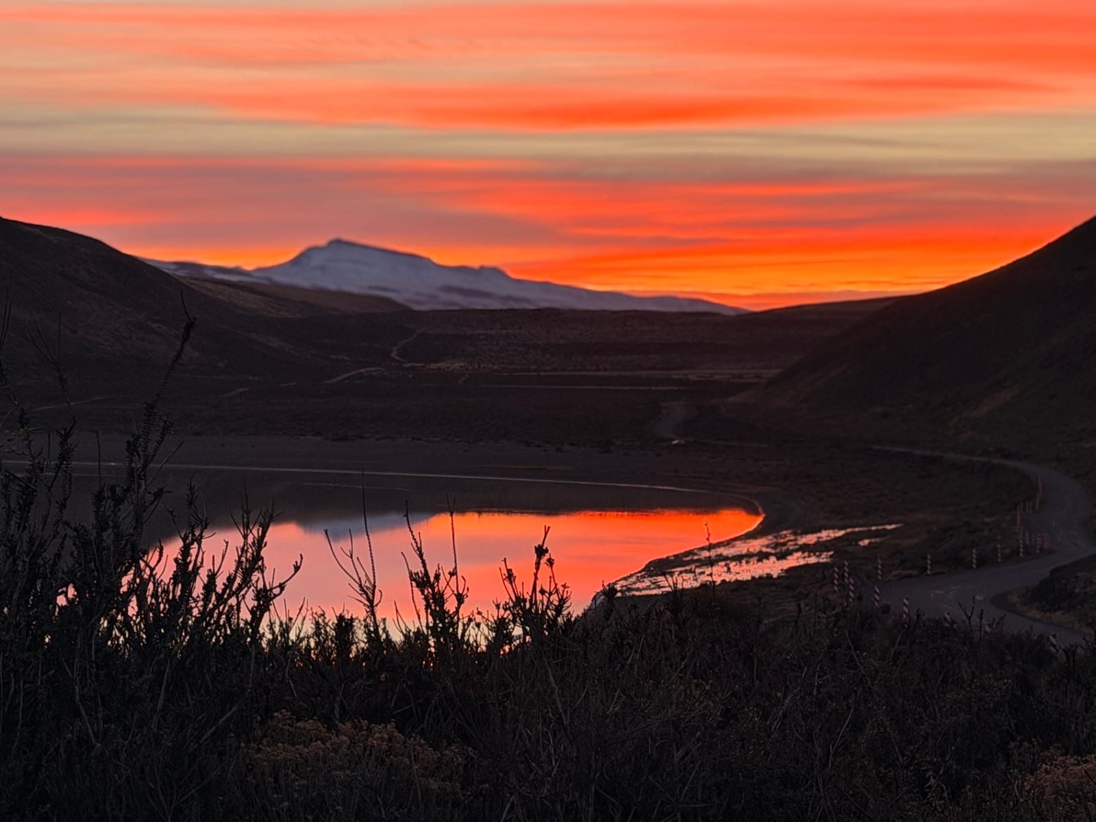 Snow-capped Patagonian peaks reflected in a still lake at first light